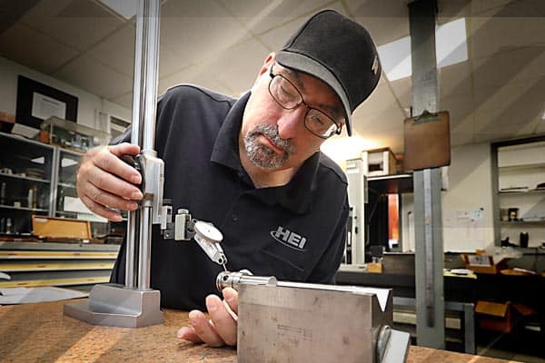Employee testing precision machined parts